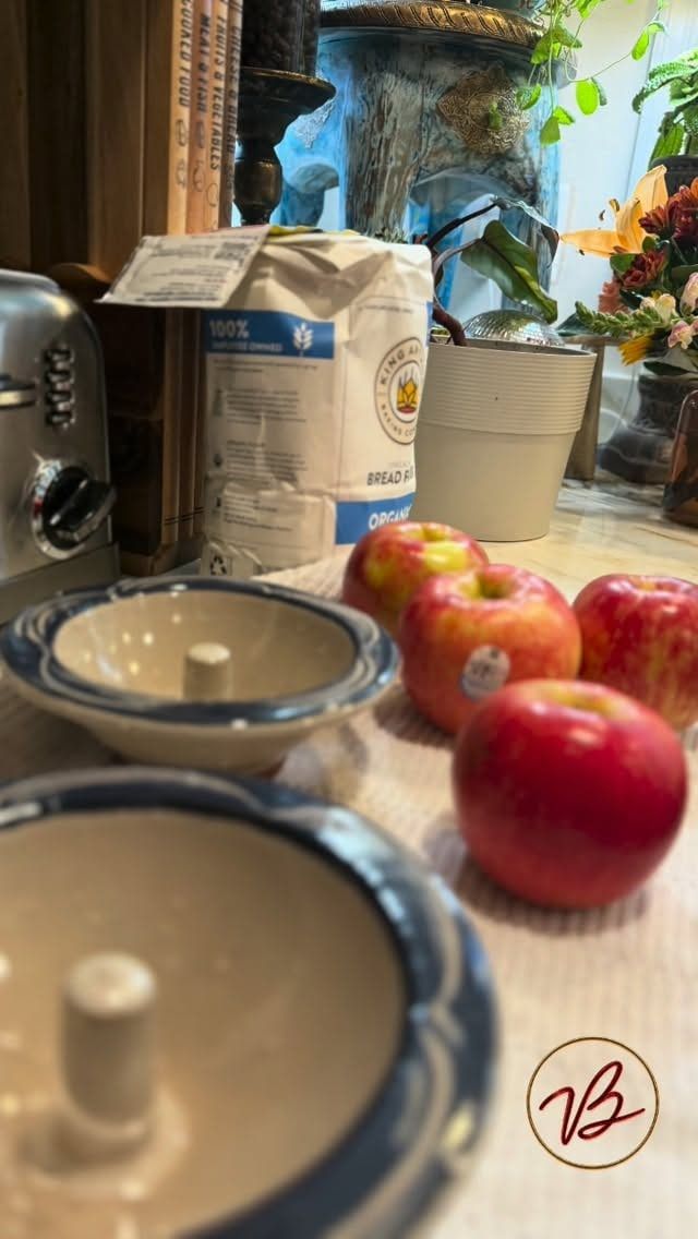 Red apples and stoneware bowls on a kitchen counter, ready for baked apples