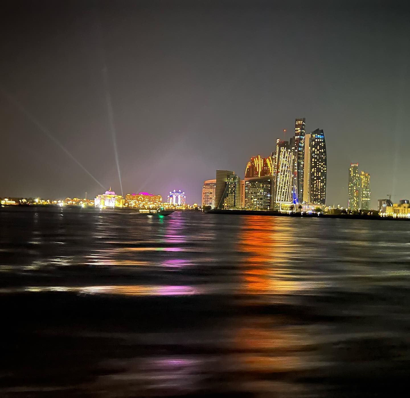 The Abu Dhabi skyline lit up at night across the water